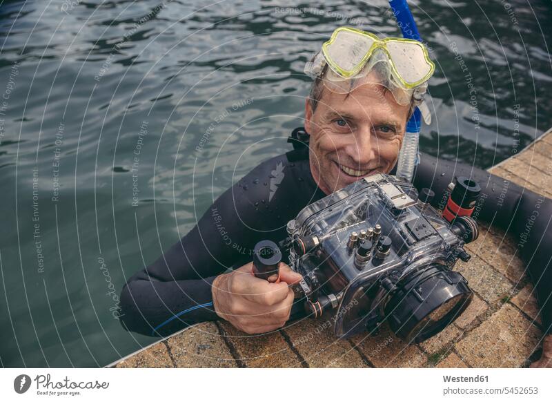 Porträt eines glücklichen Mannes mit Unterwasser-DSLR-Kamerakoffer im Wasser Kameras tauchen lächeln Männer männlich Fotoapparat Fotokamera Taucher Erwachsener