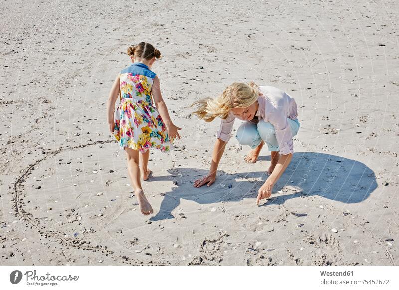 Mutter und Tochter am Strand beim Herzziehen Mami Mutti Mütter Mama Töchter Beach Straende Strände Beaches glücklich Glück glücklich sein glücklichsein Eltern