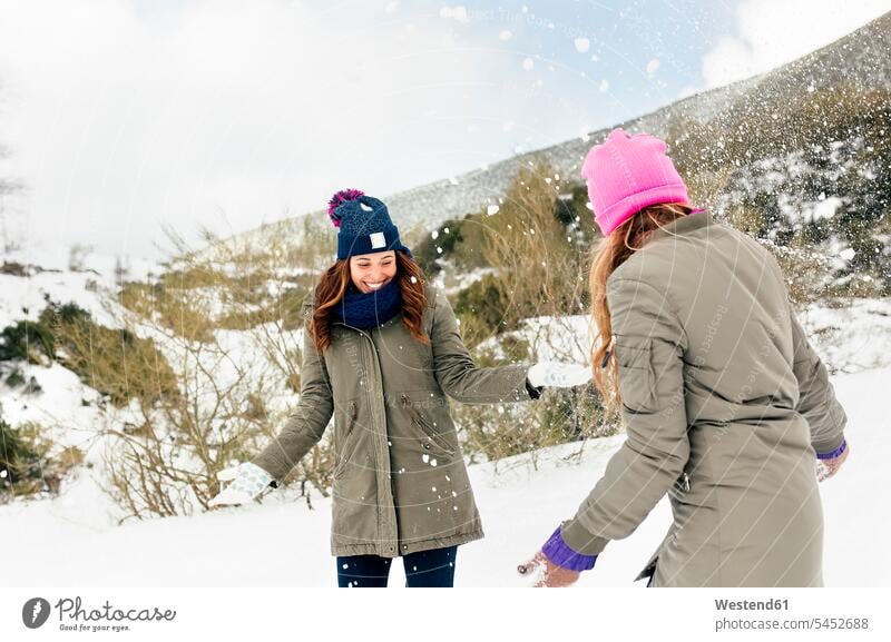Zwei Freunde amüsieren sich im Schnee Freundschaft Kameradschaft lachen werfen Wurf Freundinnen Winter winterlich Winterzeit positiv Emotion Gefühl Empfindung