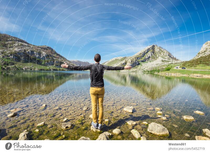 Spanien, Asturien, Nationalpark Picos de Europa, Mann steht mit erhobenen Armen an den Seen von Covadonga stehen stehend glücklich Glück glücklich sein