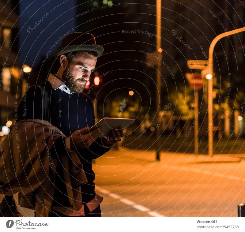 Stilvoller junger Mann mit Tablette auf nächtlicher Stadtstraße Tablet Computer Tablet-PC Tablet PC iPad Tablet-Computer Nacht nachts Männer männlich Rechner