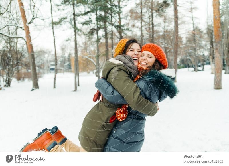 Zwei beste Freunde amüsieren sich im Schnee umarmen Umarmung Umarmungen Arm umlegen Freundinnen Freundschaft Kameradschaft glücklich Glück glücklich sein