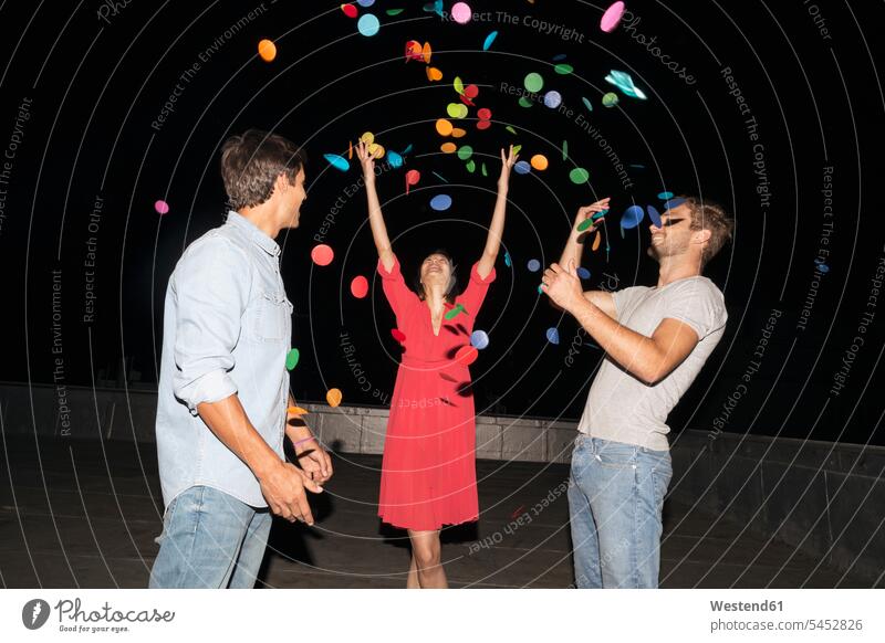 Junge Leute feiern eine Dachparty, werfen Konfetti lächeln glücklich Glück glücklich sein glücklichsein Confetti Freunde Party Parties Partys Dachterrasse