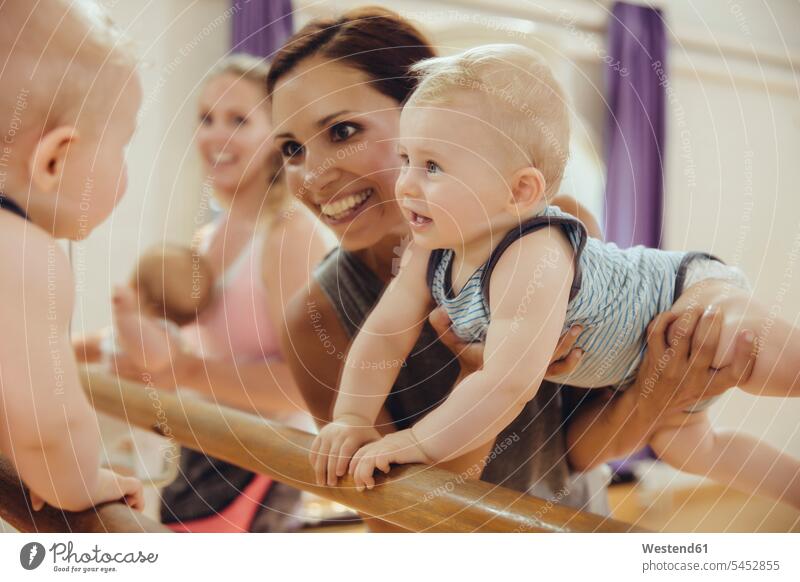 Mutter hält ihr Baby im Tanzstudio zum Fässchen hoch Spiegel trainieren lächeln Ballettstange Ballettstangen Stangen Spaß Spass Späße spassig Spässe spaßig