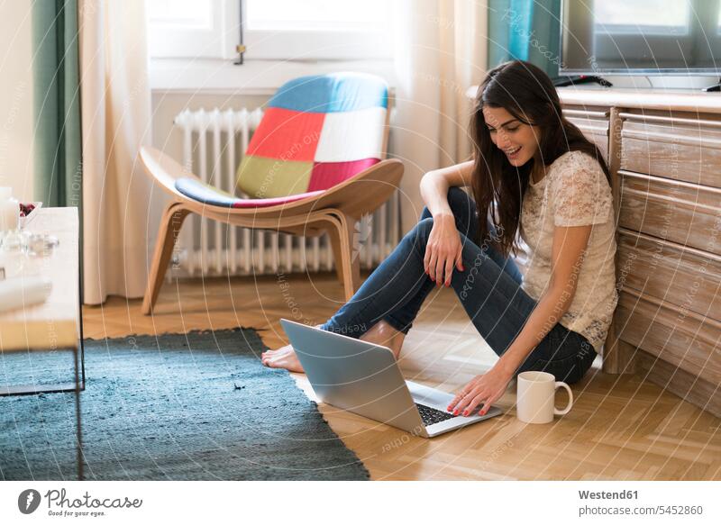 Junge Frau sitzt zu Hause mit Laptop auf dem Boden Notebook Laptops Notebooks weiblich Frauen Computer Rechner Erwachsener erwachsen Mensch Menschen Leute