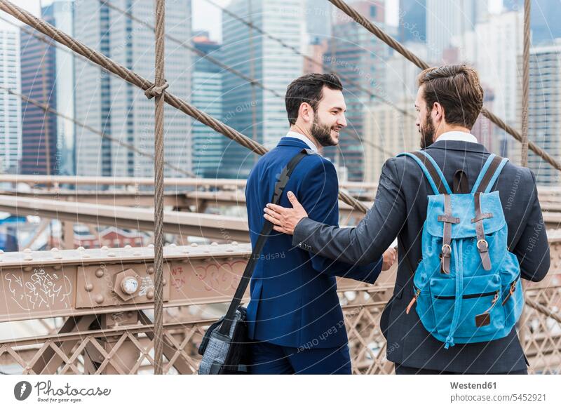 USA, New York City, zwei Geschäftsleute auf der Brooklyn Bridge sprechen reden Brücke Bruecken Brücken Geschäftsmann Businessmann Businessmänner Geschäftsmänner