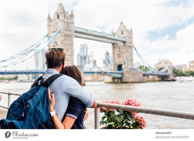 UK, London, verliebtes Paar schaut auf die Tower Bridge Pärchen Paare Partnerschaft umarmen Umarmung Umarmungen Arm umlegen England Großbritannien