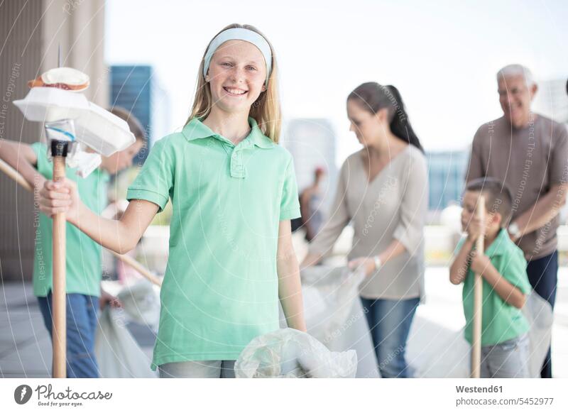 Gruppe ehrenamtlich arbeitender Kinder, die mit Abfallstöcken Müll sammeln Müllpicker Mülltüte Schüler Tüte Schulkind Bildung Schulprojekt freiwillig
