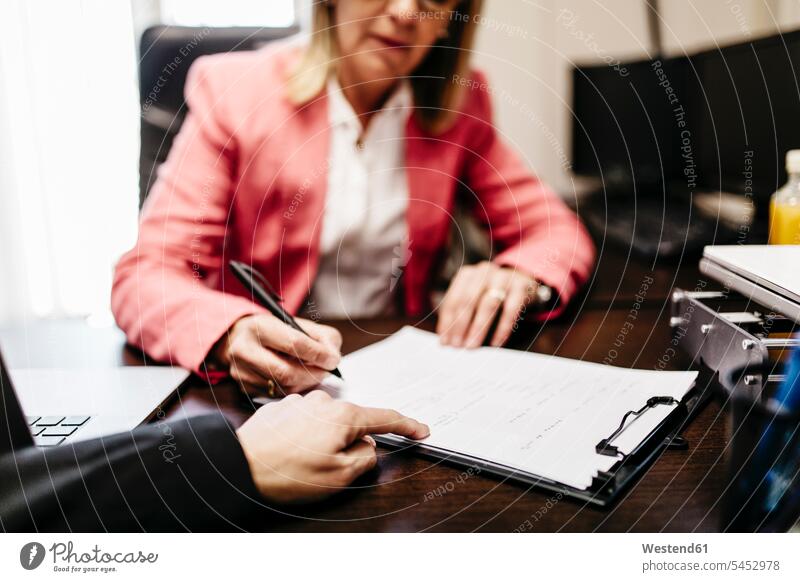 Zwei Geschäftsfrauen arbeiten im Amt an einem Dokument Arbeit schreiben aufschreiben notieren schreibend Schrift Büro Office Büros Businesswomen Businessfrauen