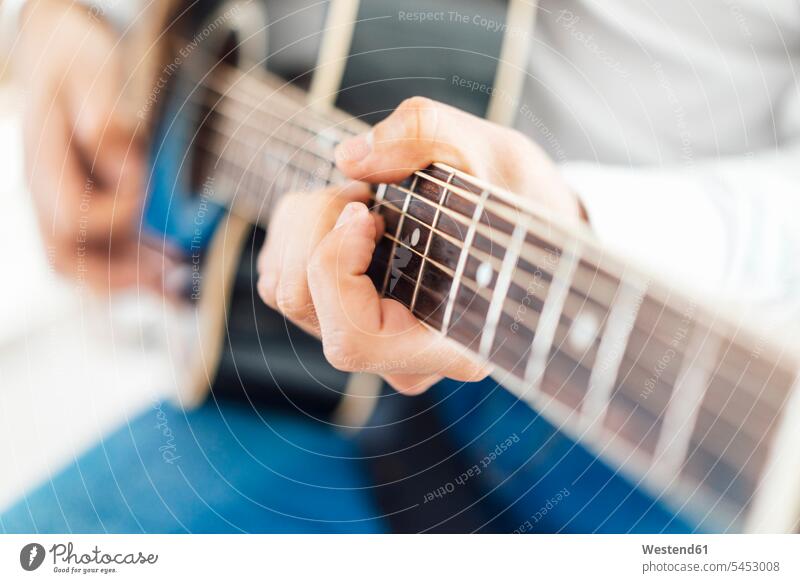 Mann mit Akustikgitarre, Nahaufnahme musizieren Musik machen Gitarre Gitarren Hand Hände Saiteninstrument Saiteninstrumente Musikinstrument Musikinstrumente