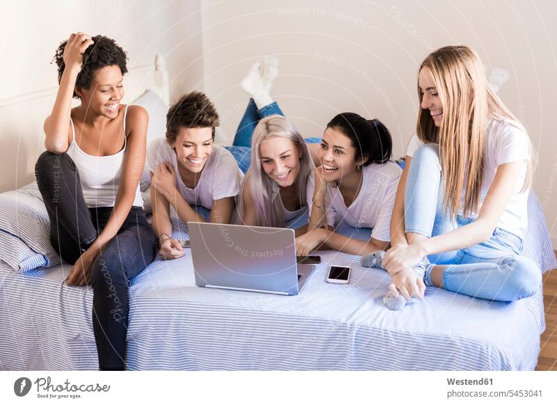Glückliche Freundinnen mit Laptop im Schlafzimmer Bett Betten glücklich glücklich sein glücklichsein Frau weiblich Frauen Notebook Laptops Notebooks Zuhause