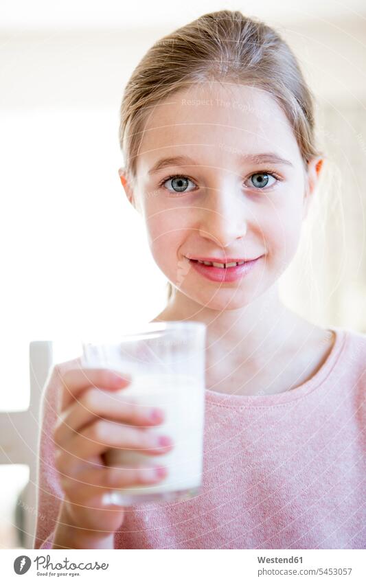 Porträt eines lächelnden Mädchens mit einem Glas Milch weiblich Kind Kinder Kids Mensch Menschen Leute People Personen Getränk Getraenk Getränke Getraenke