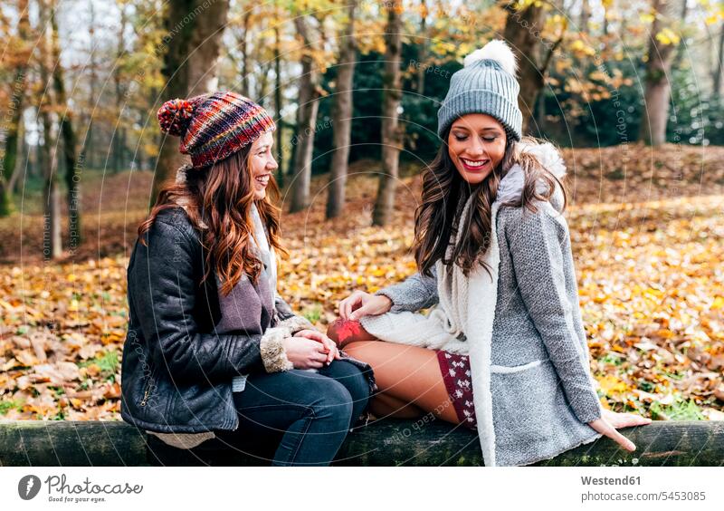 Zwei hübsche Frauen amüsieren sich in einem herbstlichen Wald Forst Wälder Freundinnen schön Spaß Spass Späße spassig Spässe spaßig weiblich Herbst Freunde