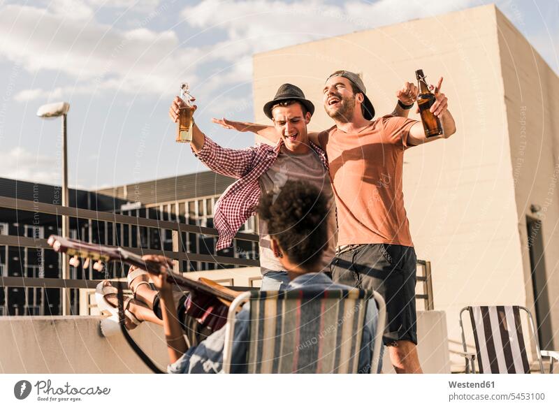 Drei Freunde feiern eine Party auf dem Dach trinken Parties Partys Bier Spaß Spass Späße spassig Spässe spaßig Dachterrasse Dachterrassen Feier Fest