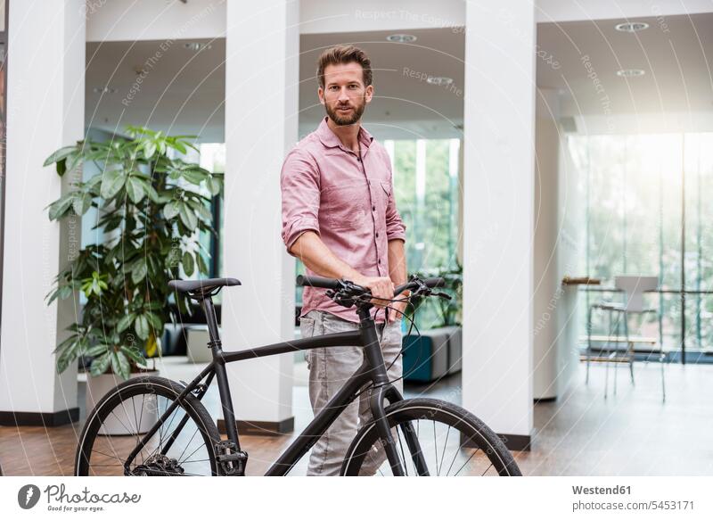 Porträt eines Mannes mit Fahrrad im Büro Bikes Fahrräder Räder Rad Männer männlich Raeder Erwachsener erwachsen Mensch Menschen Leute People Personen Business