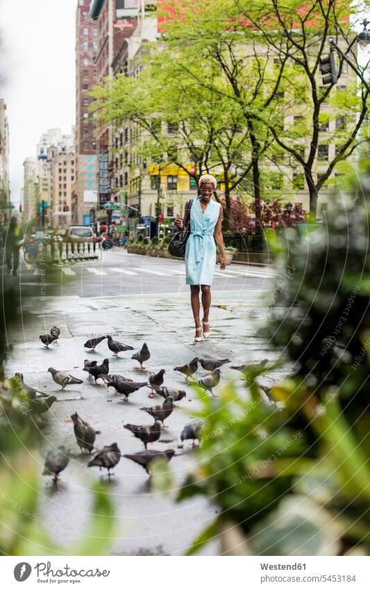 USA, New York, junge blonde afro-amerikanische Frau, die auf der Straße geht, Tauben Afroamerikanisch Afro-Amerikanisch Afroamerikaner Afro-Amerikaner