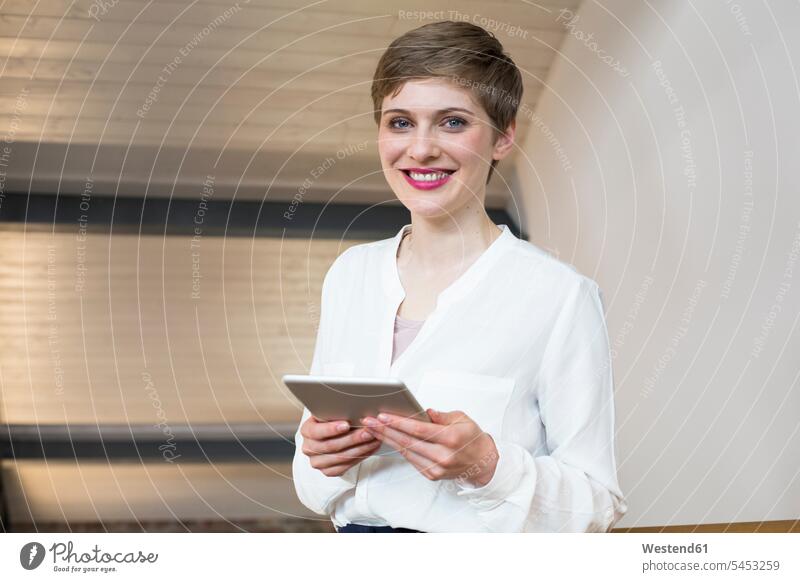 Porträt einer lächelnden Geschäftsfrau, die ein Tablett hält Frau weiblich Frauen Tablet Computer Tablet-PC Tablet PC iPad Tablet-Computer Geschäftsfrauen