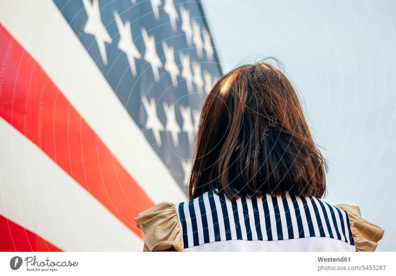USA, Rückenansicht der Frau vor Stars And Stripes Nationalfarben weiblich Frauen Erwachsener erwachsen Mensch Menschen Leute People Personen Nationalflagge