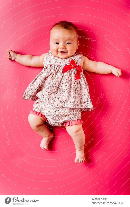 Porträt eines glücklichen Mädchens auf rosa Hintergrund Portrait Porträts Portraits liegen liegend liegt Babyportrait Babyportraits Babies Babys Säuglinge Kind