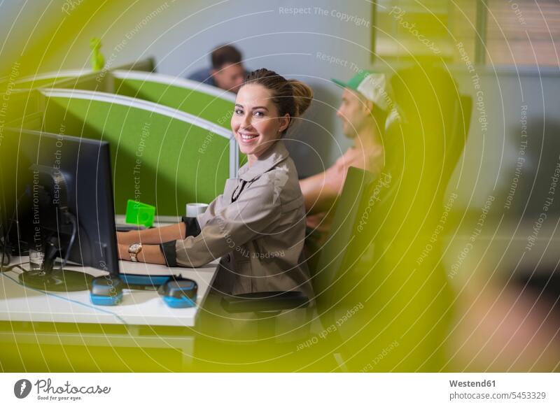 Junge Frau arbeitet am Computer in einer Bürokabine weiblich Frauen Rechner lächeln Office Büros arbeiten Arbeit Erwachsener erwachsen Mensch Menschen Leute