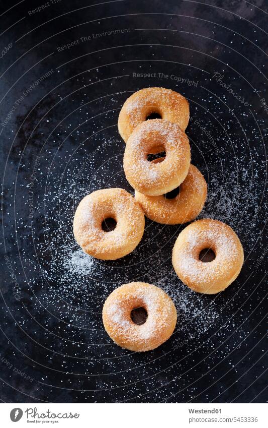 Sechs Mini-Doughnuts mit Zucker bestreut auf dunklem Grund Niemand Genuss genießen Genuß geniessen Gebäck Backware Gebaeck Backwaren Donut Donuts gebacken