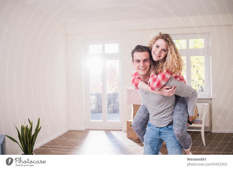 Porträt eines glücklichen jungen Paares in neuem Zuhause Spaß Spass Späße spassig Spässe spaßig Pärchen Partnerschaft Wohnung wohnen Wohnungen Mensch Menschen