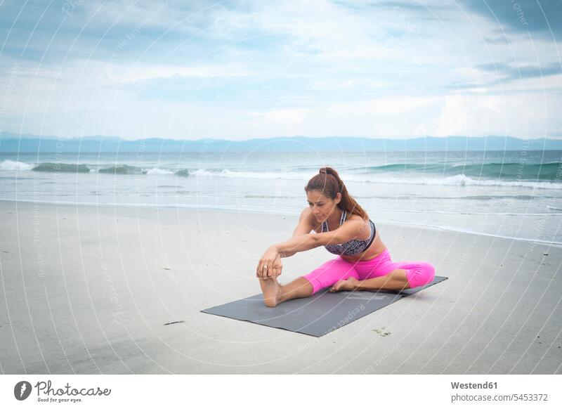Frau praktiziert Yoga am Strand Beach Straende Strände Beaches strecken dehnen Yoga-Übungen Yogauebungen Yogaübungen Jogauebung Jogauebungen üben ausüben