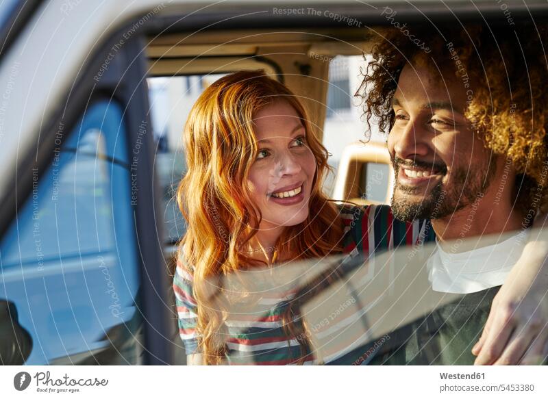 Lächelnde junge Frau, die ihren Freund in einem Auto ansieht lächeln ansehen Wagen PKWs Automobil Autos Paar Pärchen Paare Partnerschaft glücklich Glück