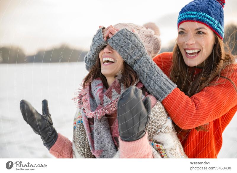 Verspielte Freunde auf gefrorenem See Spaß Spass Späße spassig Spässe spaßig Frau weiblich Frauen Freundinnen lachen glücklich Glück glücklich sein