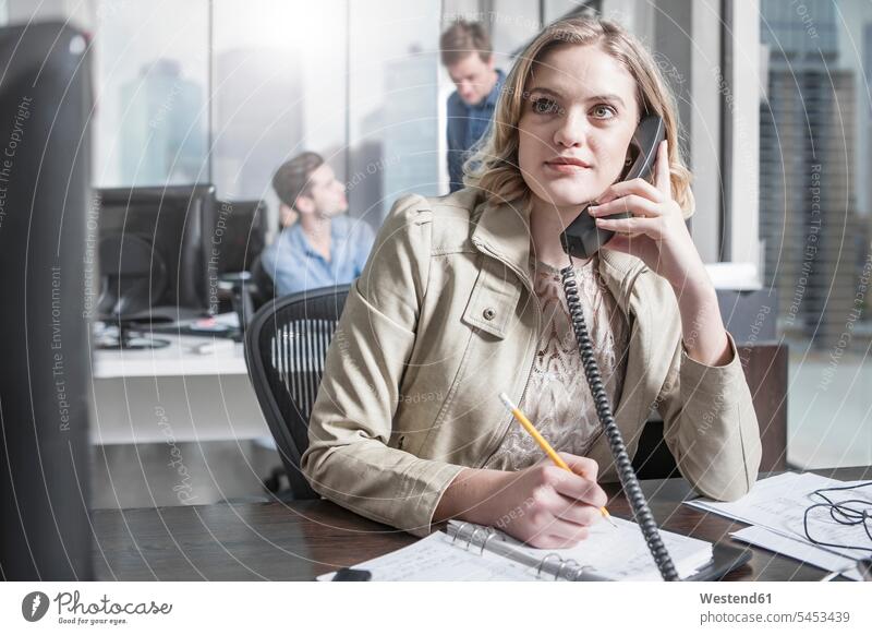 Junge Frau am Schreibtisch im Büro am Telefon weiblich Frauen Office Büros telefonieren anrufen Anruf telephonieren Erwachsener erwachsen Mensch Menschen Leute