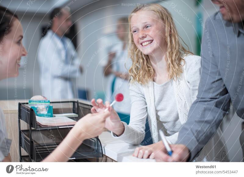 Krankes Mädchen bekommt Lolli von Empfangsdame im Hosptal Arzt Doktoren Ärzte lachen Patientin Patientinnen Klinik Kliniken Krankenhaus Krankenhäuser