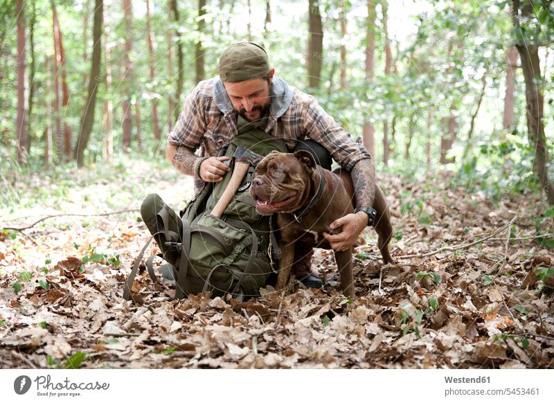 Mann mit Hund im Wald Forst Wälder Männer männlich Hunde wandern Wanderung Erwachsener erwachsen Mensch Menschen Leute People Personen Haustier Haustiere Tier