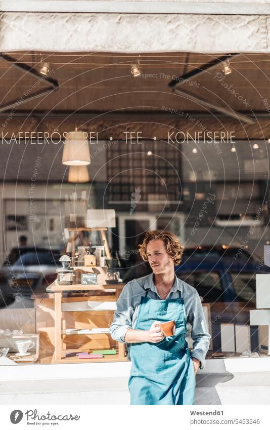 Kaffeeröster hält Tasse vor seinem Geschäft Portrait Porträts Portraits Shop Laden Läden Geschäfte Shops Mann Männer männlich Einzelhandel Handel handeln