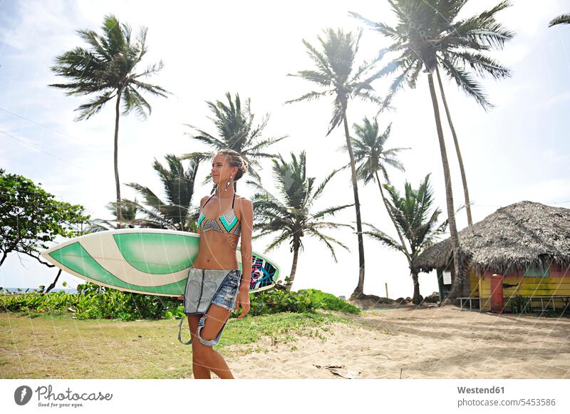 Frau an der Küste mit Surfbrett gehen gehend geht Surfen Surfing Wellenreiten Strand Beach Straende Strände Beaches Surfbretter surfboard surfboards weiblich
