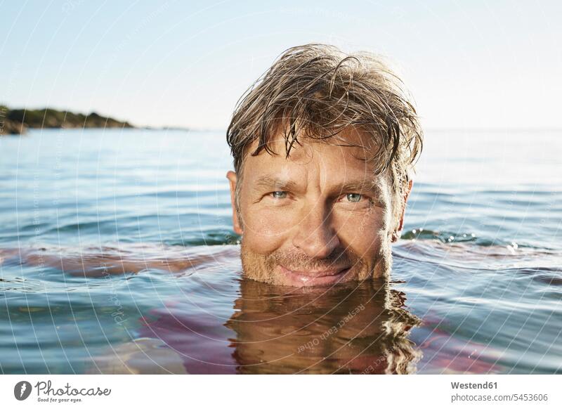 Porträt eines lächelnden Mannes beim Baden im Meer Meere Männer männlich Gewässer Wasser Erwachsener erwachsen Mensch Menschen Leute People Personen baden