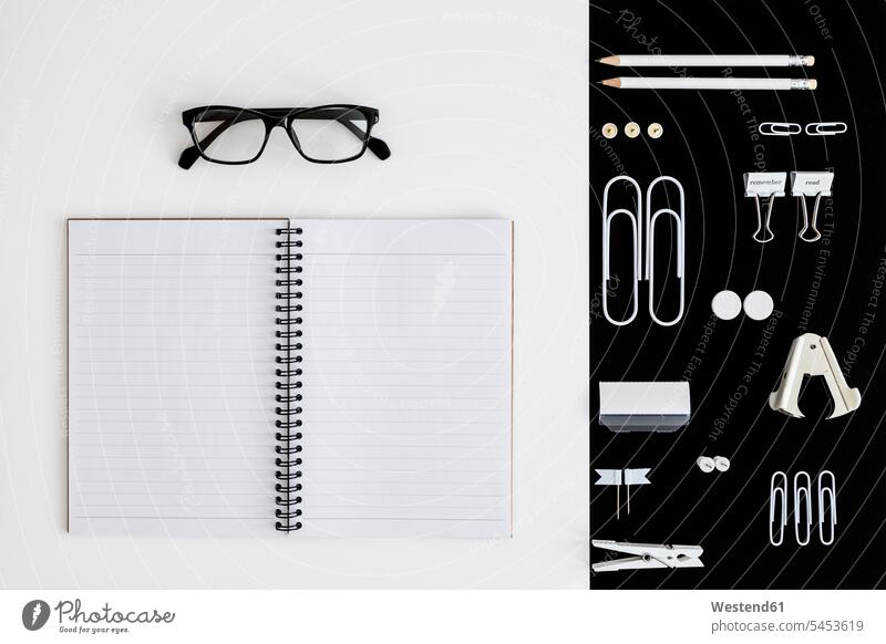 Weiße Büroutensilien auf schwarzem Hintergrund und Notizblock und Brille auf weißem Hintergrund geöffnet offen aufgeklappt Office Büros Brillen Do-it-Yourself