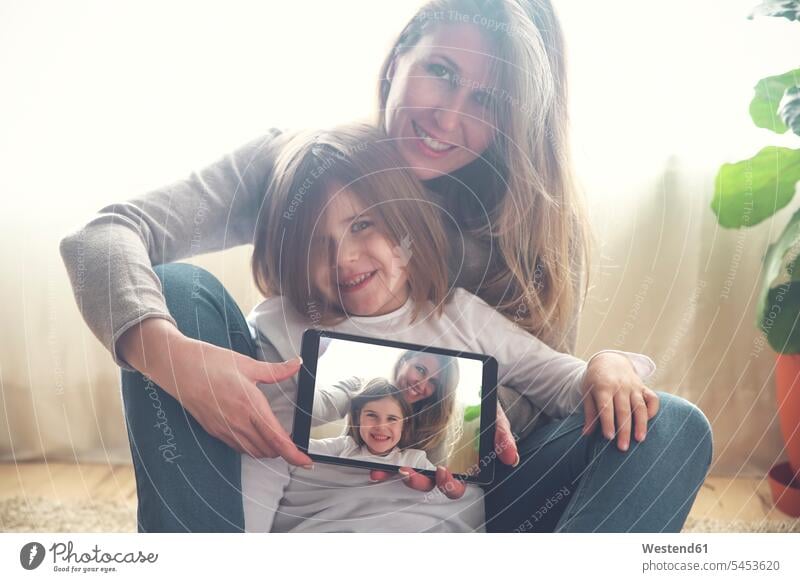 Porträt von Mutter und kleiner Tochter zu Hause mit Tablet und Selfie Töchter Mami Mutti Mütter Mama Tablet Computer Tablet-PC Tablet PC iPad Tablet-Computer