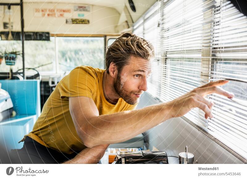 Mann in einem alten Bus, der durch eine Sonnenblende schaut Jalousie Männer männlich beobachten zuschauen ansehen Erwachsener erwachsen Mensch Menschen Leute
