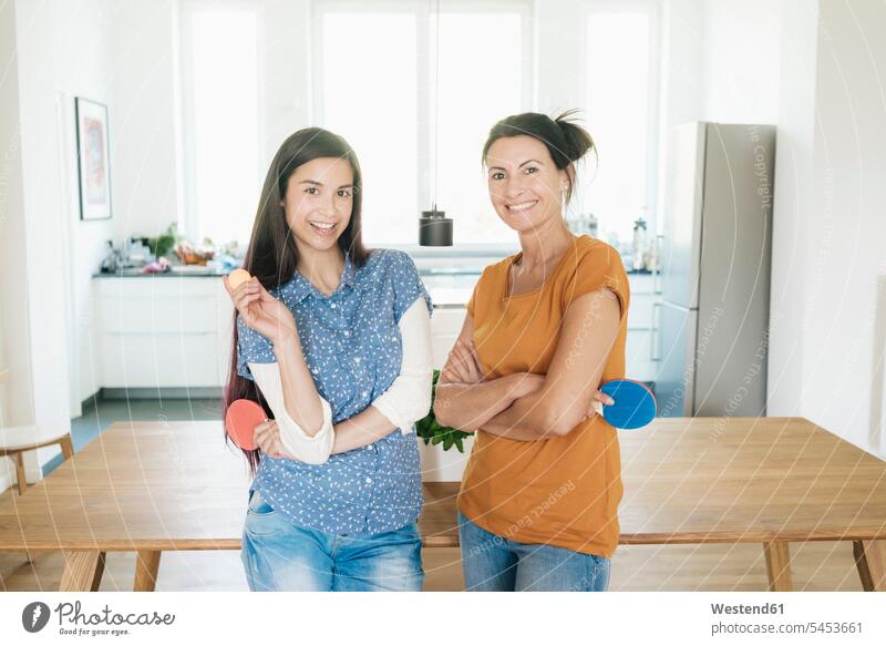Porträt von zwei lächelnden Frauen, die zu Hause Tischtennisschläger halten weiblich Pingpong Tischtennisspiel Erwachsener erwachsen Mensch Menschen Leute