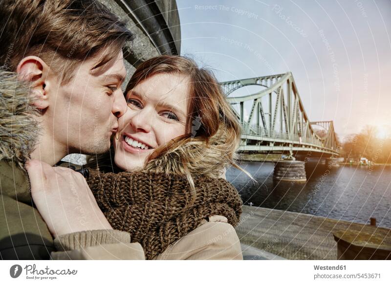 Deutschland, Potsdam, junges Paar küsst sich an der Glienicker Brücke küssen Küsse Kuss Pärchen Paare Partnerschaft umarmen Umarmung Umarmungen Arm umlegen