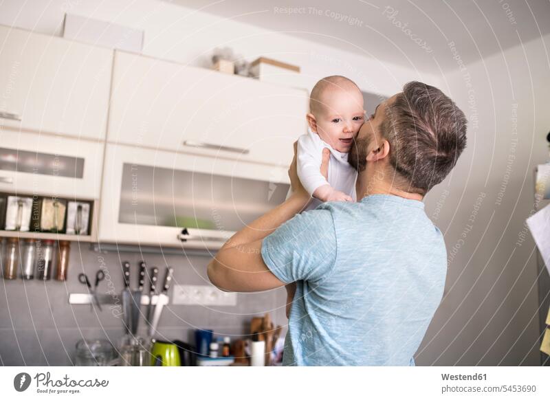 Vater hält und küsst kleinen Sohn in der Küche Papas Väter Vati Vatis Papis halten Baby Babies Babys Säuglinge Kind Kinder Küchen küssen Küsse Kuss Eltern