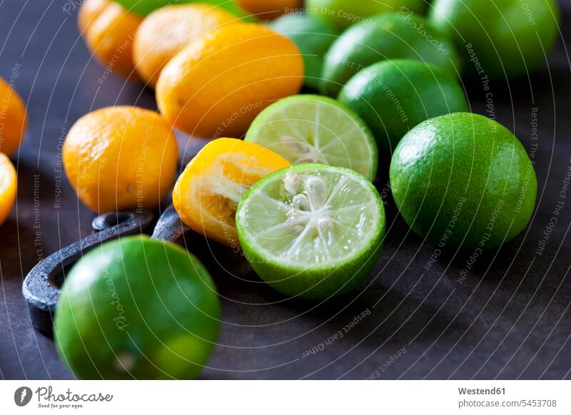 Geschnittene und ganze Kumquats und Limequats Niemand Zitrusfrucht Zitrusfruechte Zitrusfrüchte orange Ausschnitt Teil Teilansicht Teilabschnitt Anschnitt