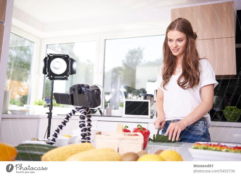 Frau beim Schneiden einer Zucchini Fotokamera Kamera Kameras Küchen Leute Menschen People Person Personen erwachsen Erwachsene Frauen weiblich Essen