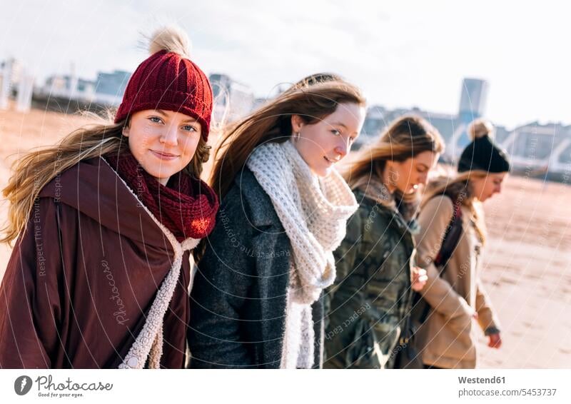 Porträt einer Teenagerin, die im Winter mit ihren Freunden am Strand spazieren geht Portraits Porträts Beach Beaches Straende Strände Kameradschaft Freundin