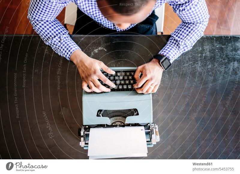 Junger Mann am Schreibtisch mit Schreibmaschine Männer männlich Arbeitstisch Schreibtische Schreibmaschinen Erwachsener erwachsen Mensch Menschen Leute People