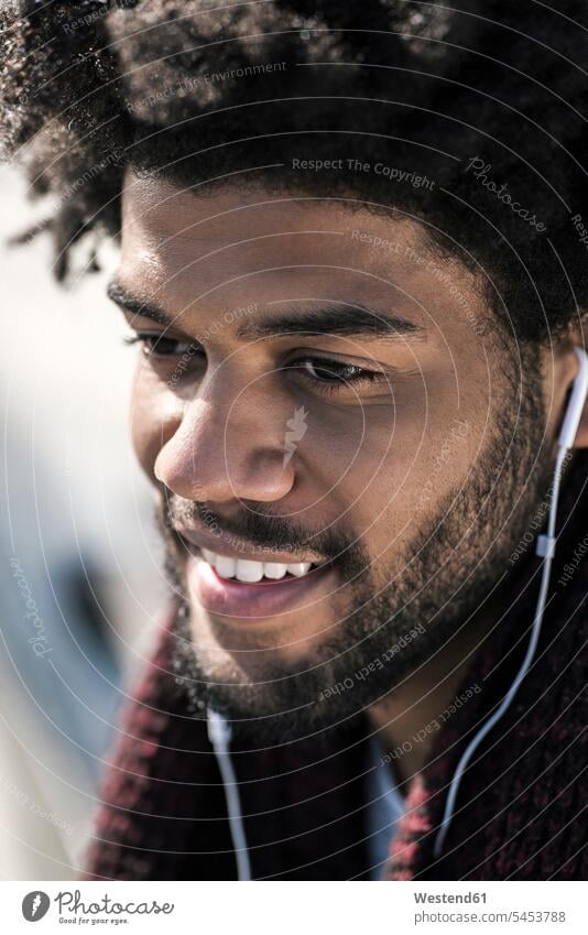 Porträt eines lächelnden Mannes, der über Kopfhörer Musik hört Männer männlich Ohrhörer Erwachsener erwachsen Mensch Menschen Leute People Personen In-Ear