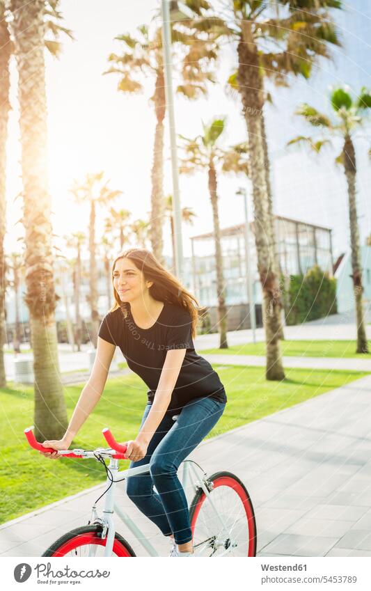 Lächelnde junge Frau auf Fixie-Bike fahren weiblich Frauen Fahrrad Bikes Fahrräder Räder Rad Erwachsener erwachsen Mensch Menschen Leute People Personen Raeder