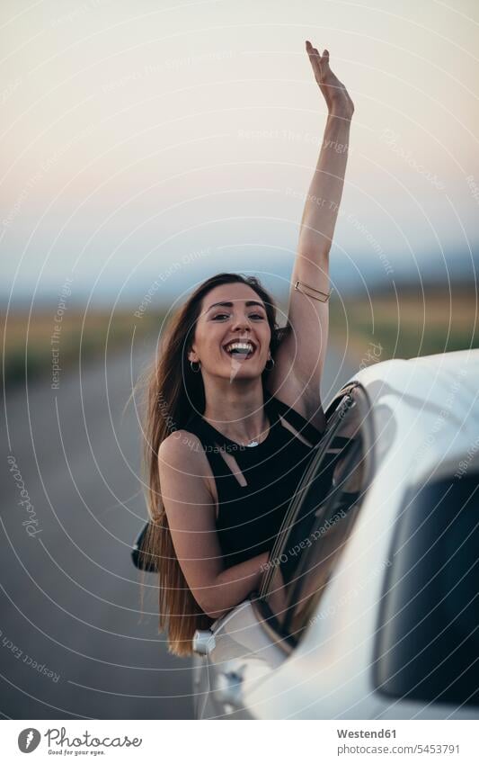 Glückliche Frau lehnt sich aus dem Autofenster autofahren Wagen PKWs Automobil Autos weiblich Frauen Spaß Spass Späße spassig Spässe spaßig Freude freuen