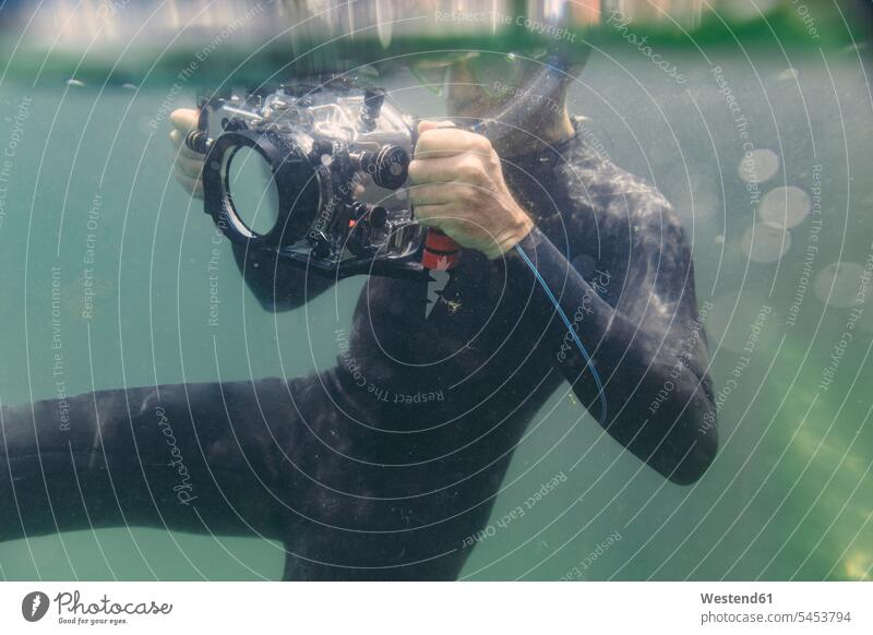 Mann taucht mit Unterwasser-DSLR-Kameratasche tauchen Kameras Männer männlich Fotoapparat Fotokamera Taucher Erwachsener erwachsen Mensch Menschen Leute People