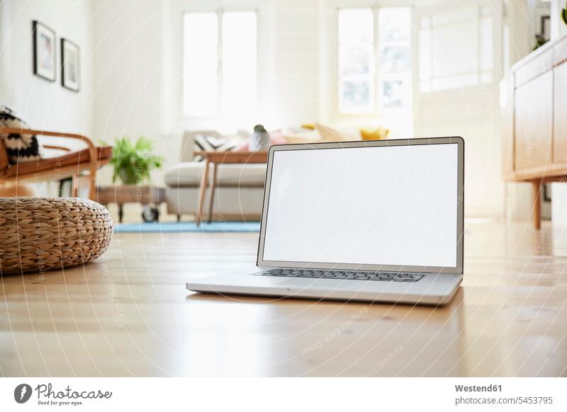 Laptop auf Holzboden stehend in einem hellen modernen Wohnzimmer eines alten Landhauses Digitalisierung Online leer leere Technologie Technologien Technik